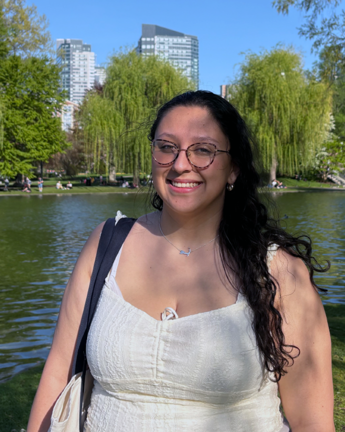 picture of a woman with wavy hair and eyeglasses in front of a pond